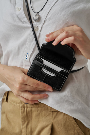 Black MIULIN 1st Anniversary Edition wallet bag showing compact design with zip closure and stylish leather exterior.