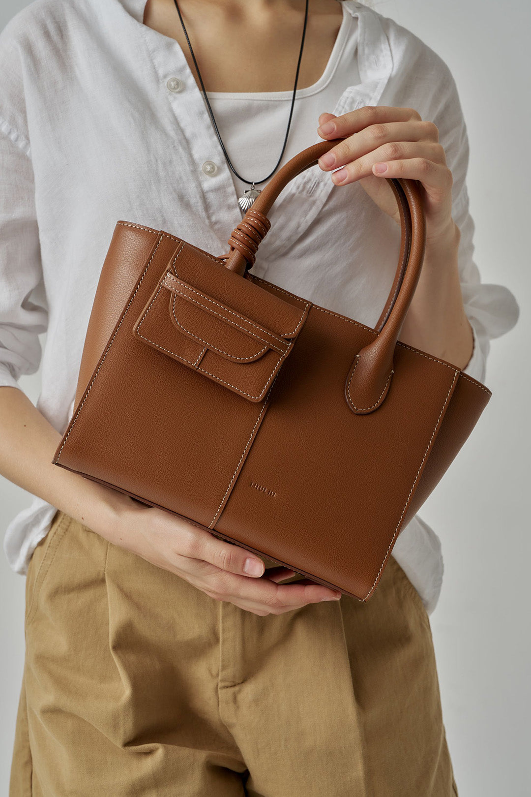 MIULIN 1st Anniversary Edition Camel Wallet Bag showing its compact design with a sleek strap and textured leather finish.