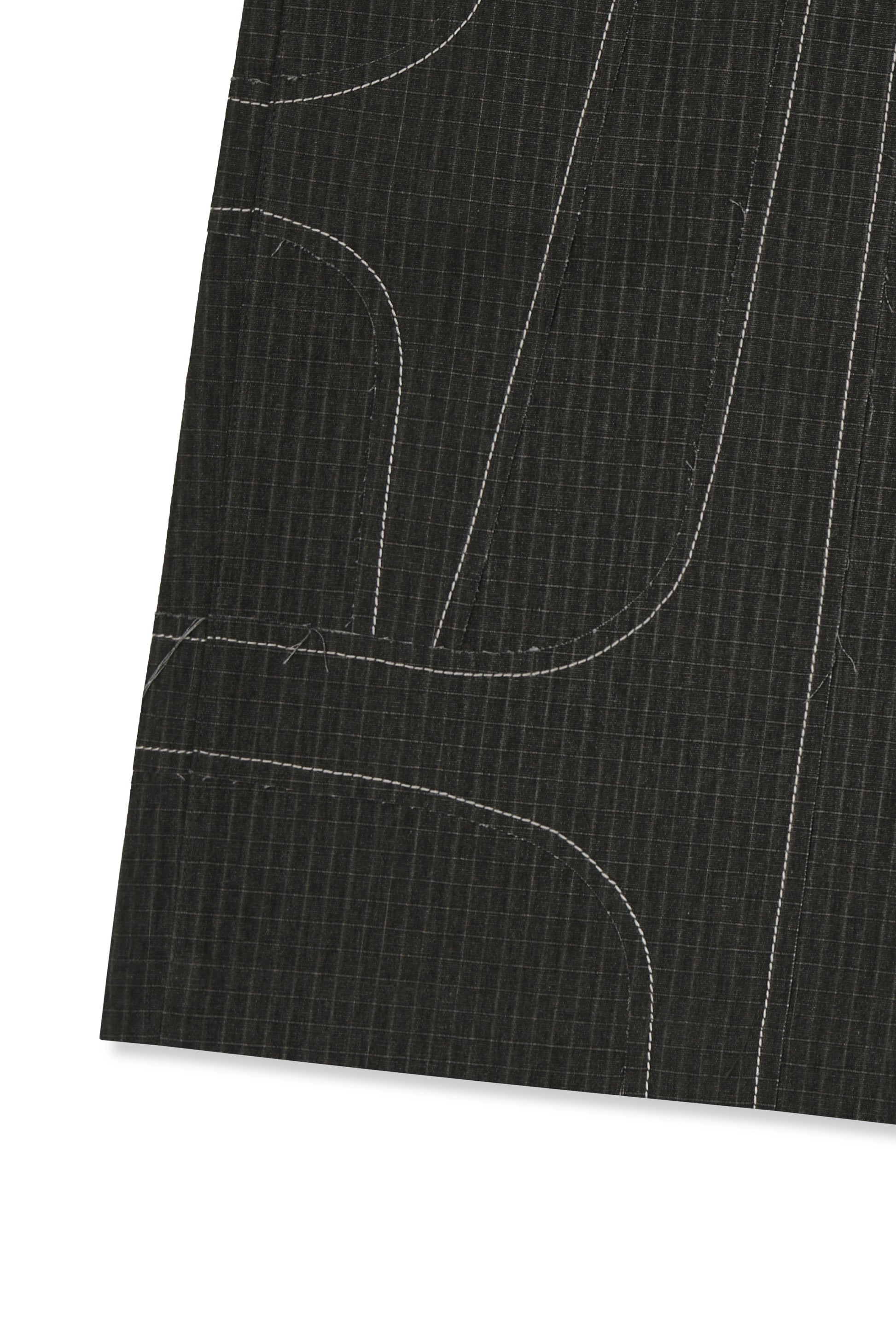 IOEDLE stitched stream shorts showing a close-up of the beige fabric with stitched detailing and relaxed fit.