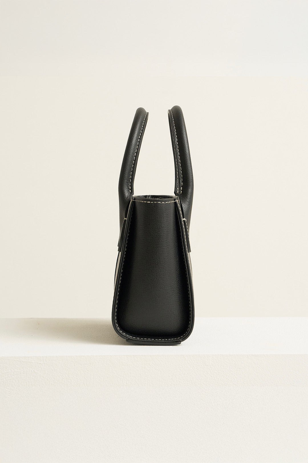 Medium MIULIN Blenged leather tote bag with sturdy handles and sleek design, shown in a natural outdoor setting.
