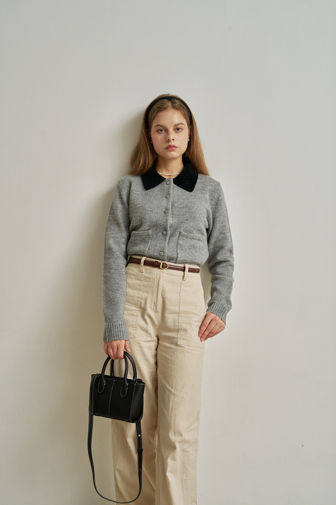 Small MIULIN Blenged leather bag showing its compact design and smooth leather texture with a top handle and subtle branding.