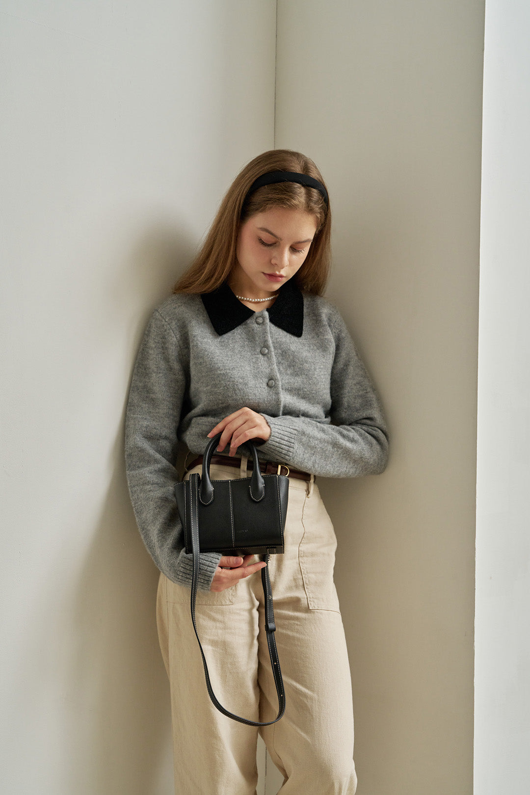 Small Blenged leather bag by MIULIN featuring a sleek design and sturdy handle on a neutral background.