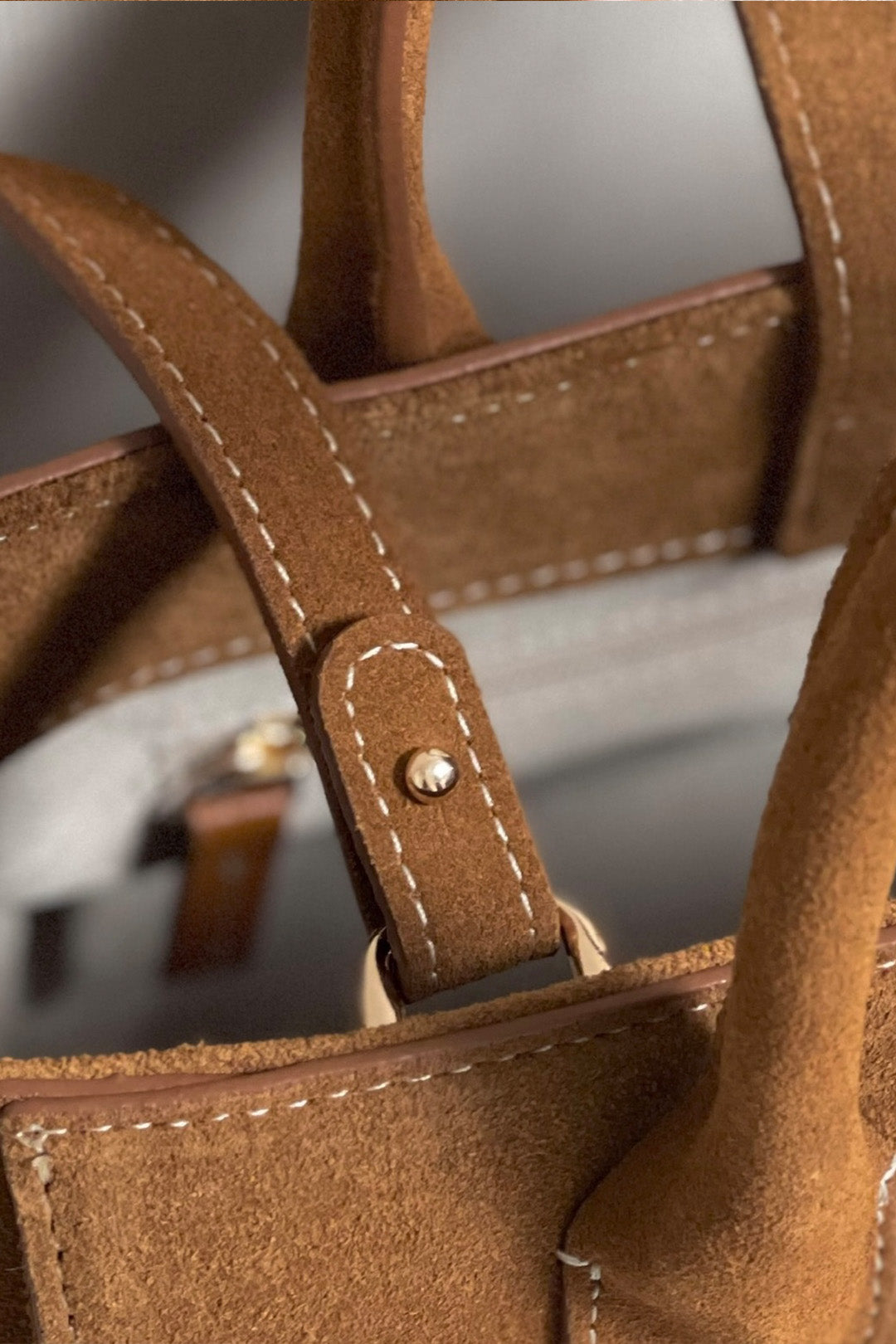 Small MIULIN Brunir suede bag with top handle and minimalist design, shown in a natural brown suede material.
