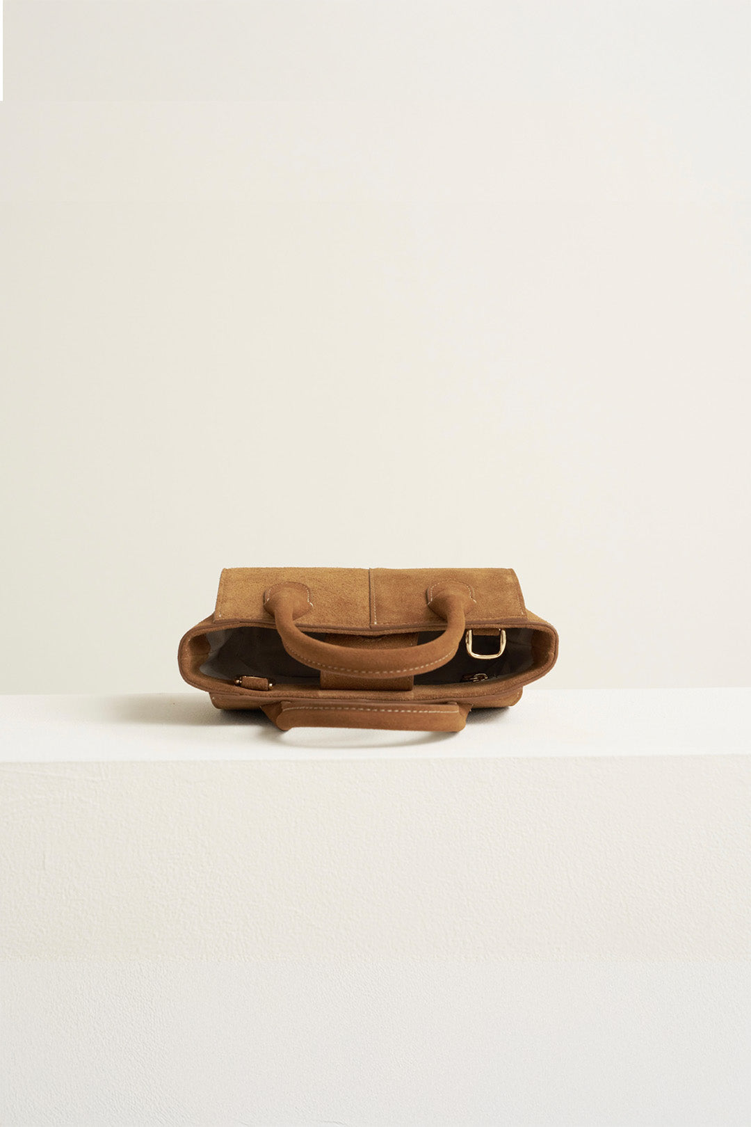 Small MIULIN Brunir suede tote bag displayed on a plain background, showcasing its soft texture and compact design.