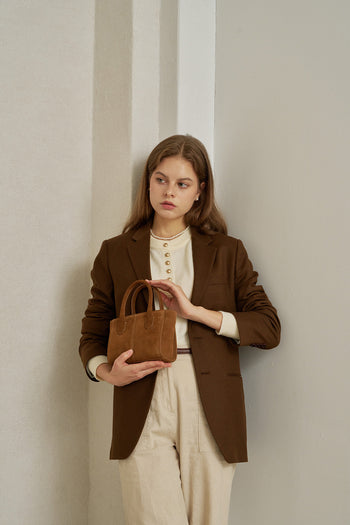 Small MIULIN Brunir suede bag with top handles and minimalist design, shown in a natural tan color.