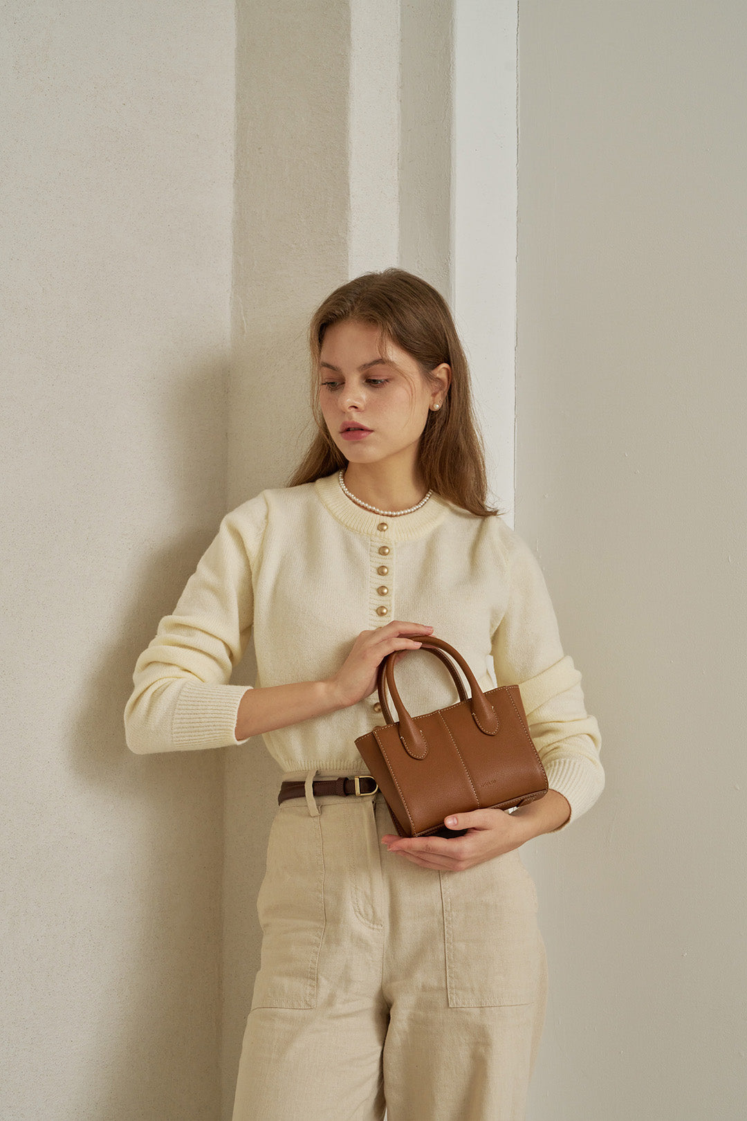 Small MIULIN Camille leather bag featuring a sleek design with a top handle and versatile style for everyday use.