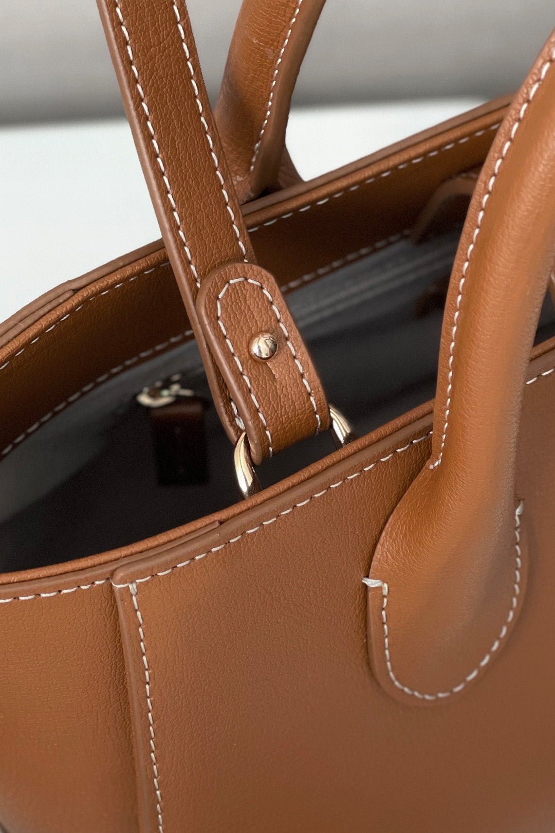Small MIULIN Camille leather bag with top handle and sleek design, showcasing its elegant craftsmanship and soft leather texture.