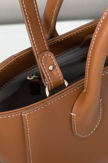 Small MIULIN Camille leather bag with top handle and sleek design, showcasing its elegant craftsmanship and soft leather texture.