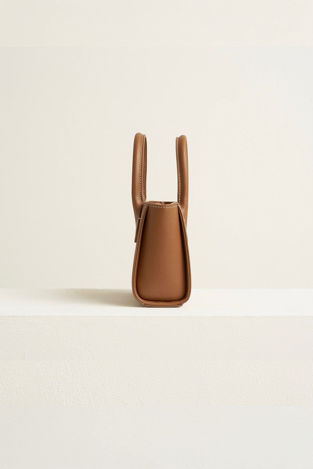 Small MIULIN Camille leather tote bag with structured design and top handles, showcasing its elegant craftsmanship.