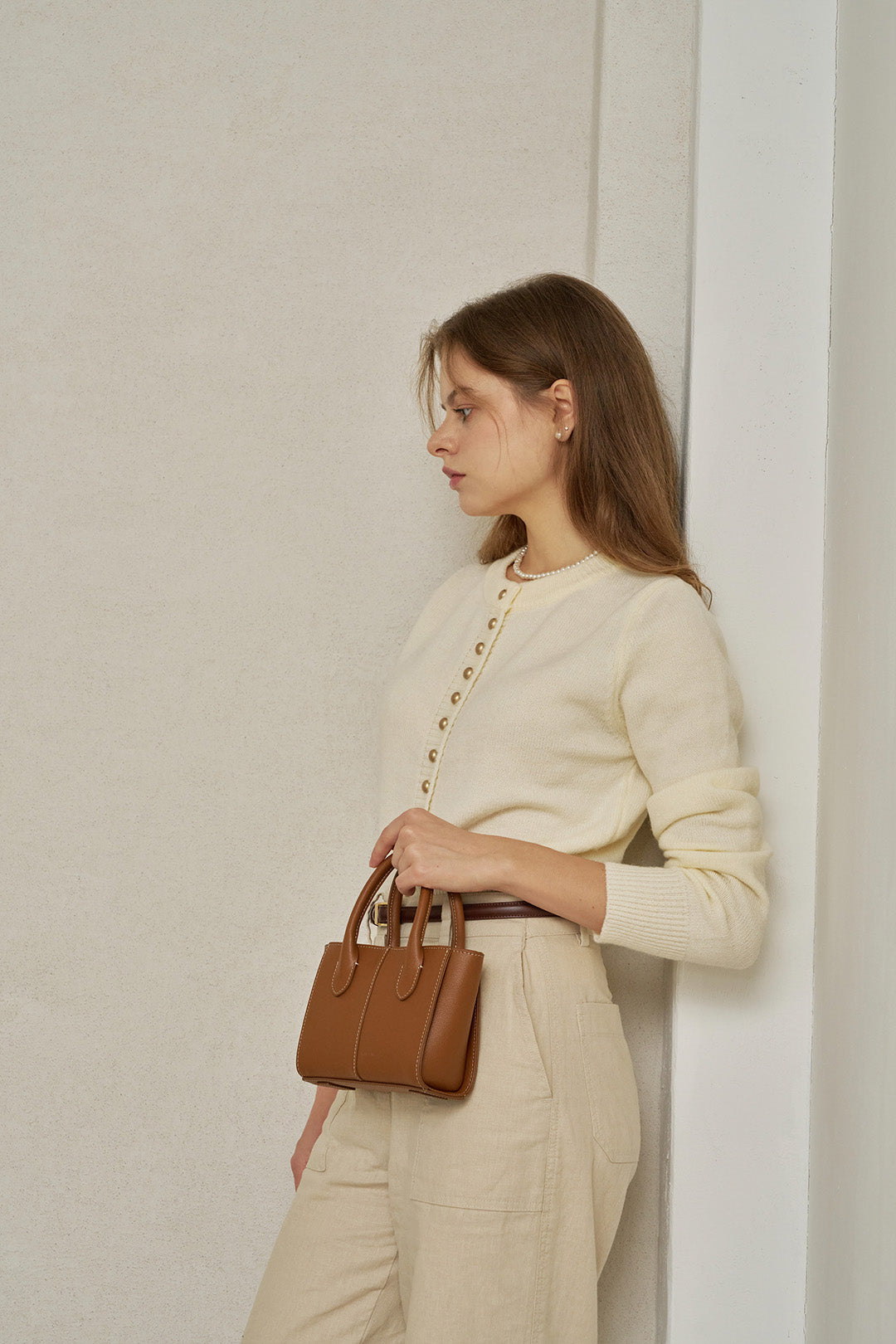 Small MIULIN Camille leather bag with sleek design and top handle, showcasing its elegant craftsmanship and compact size.