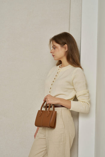 Small MIULIN Camille leather bag with sleek design and top handle, showcasing its elegant craftsmanship and compact size.
