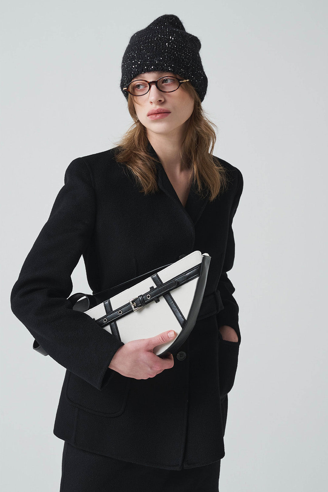 Black LE SAUT GOCHI bag with sleek design and adjustable strap, shown from the side with open top and minimal branding.