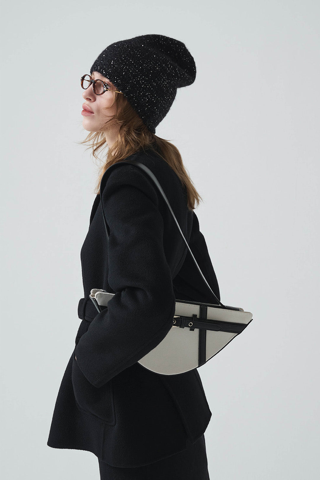 Black LE SAUT GOCHI bag with sleek design and top handle, shown from a side angle with zipper closure.