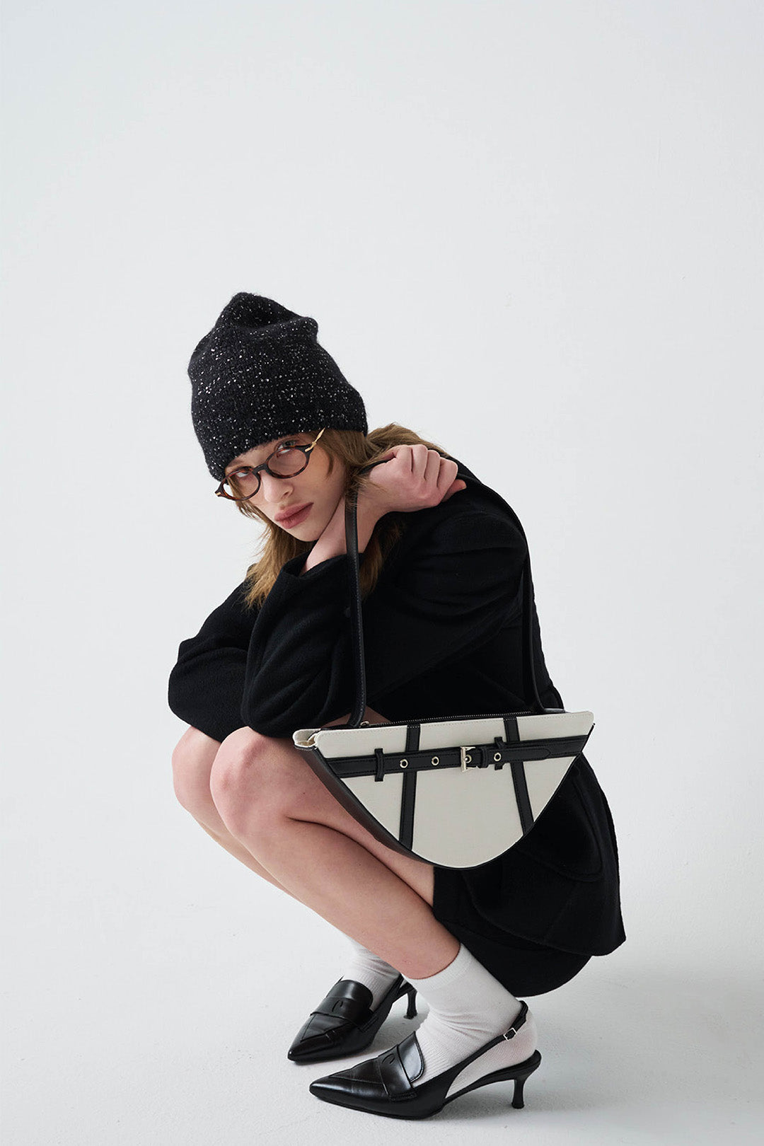 Black LE SAUT GOCHI bag with sleek design and sturdy handles, shown from a side angle.