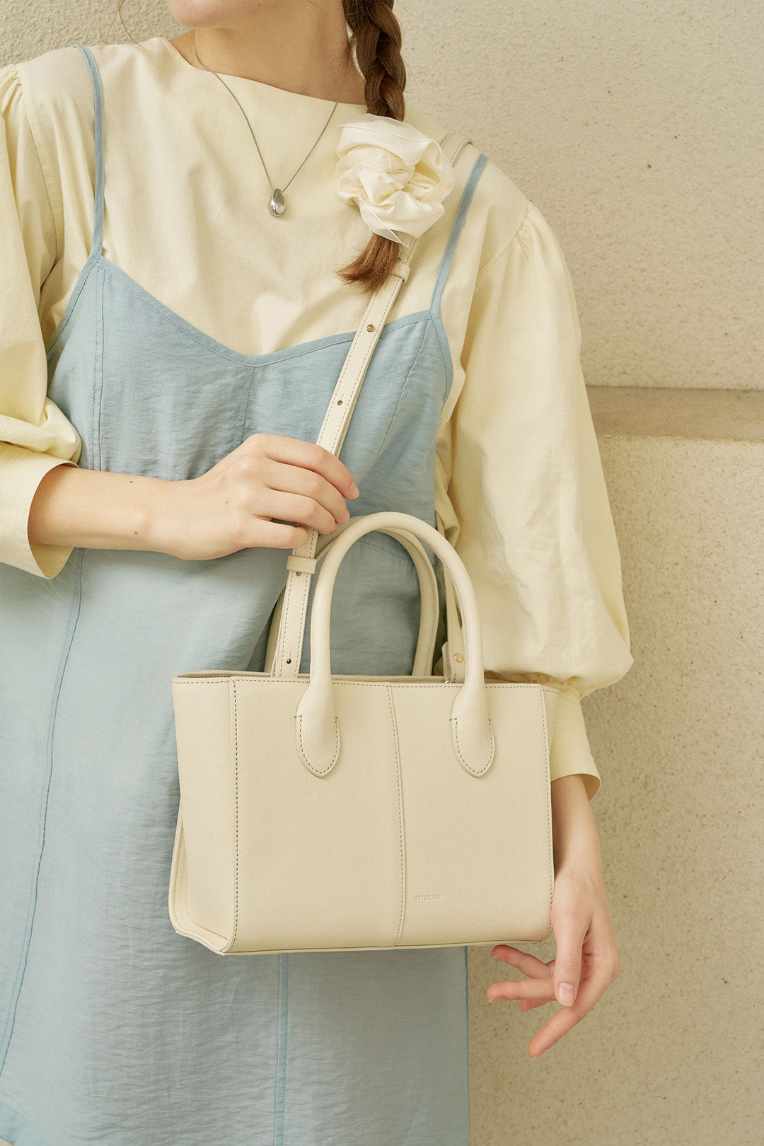 Medium Ivoire leather tote bag by MIULIN, showcasing smooth beige leather with sturdy handles and minimalist design.