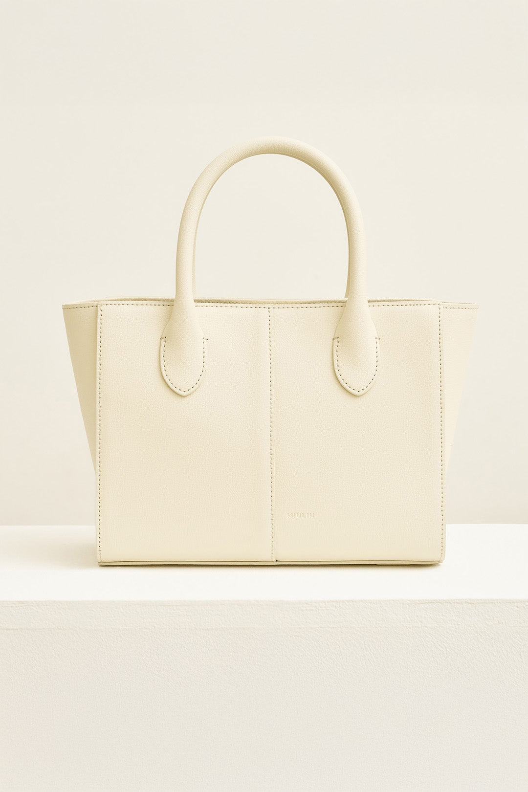 Medium Ivoire leather tote bag by MIULIN, showing the stylish beige handbag with handles and spacious interior.