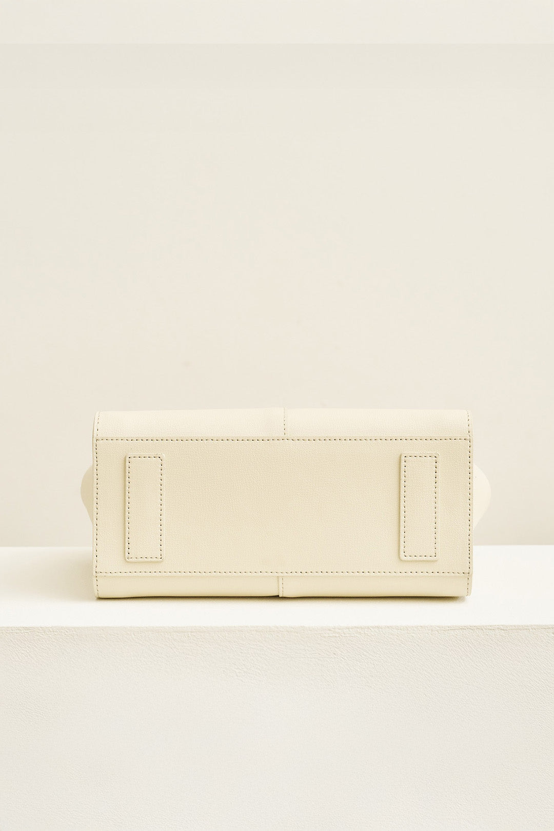 Medium Ivoire leather bag by MIULIN with sturdy handles and sleek design, showing its elegant beige color and smooth texture.