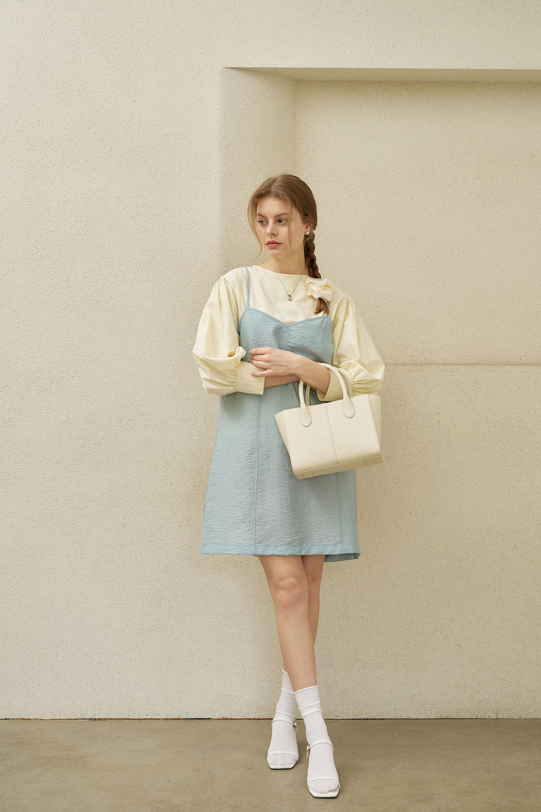Medium ivoire leather bag by MIULIN featuring a sleek, structured design with a top handle and subtle stitching details.