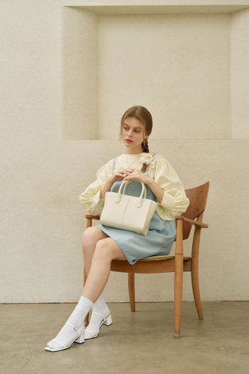 Medium ivoire leather bag by MIULIN with sturdy handles and smooth finish, showcasing elegant craftsmanship.