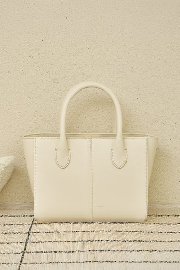 Small Ivoire leather bag by MIULIN, featuring a sleek design with top handles and smooth texture, perfect for stylish everyday use.