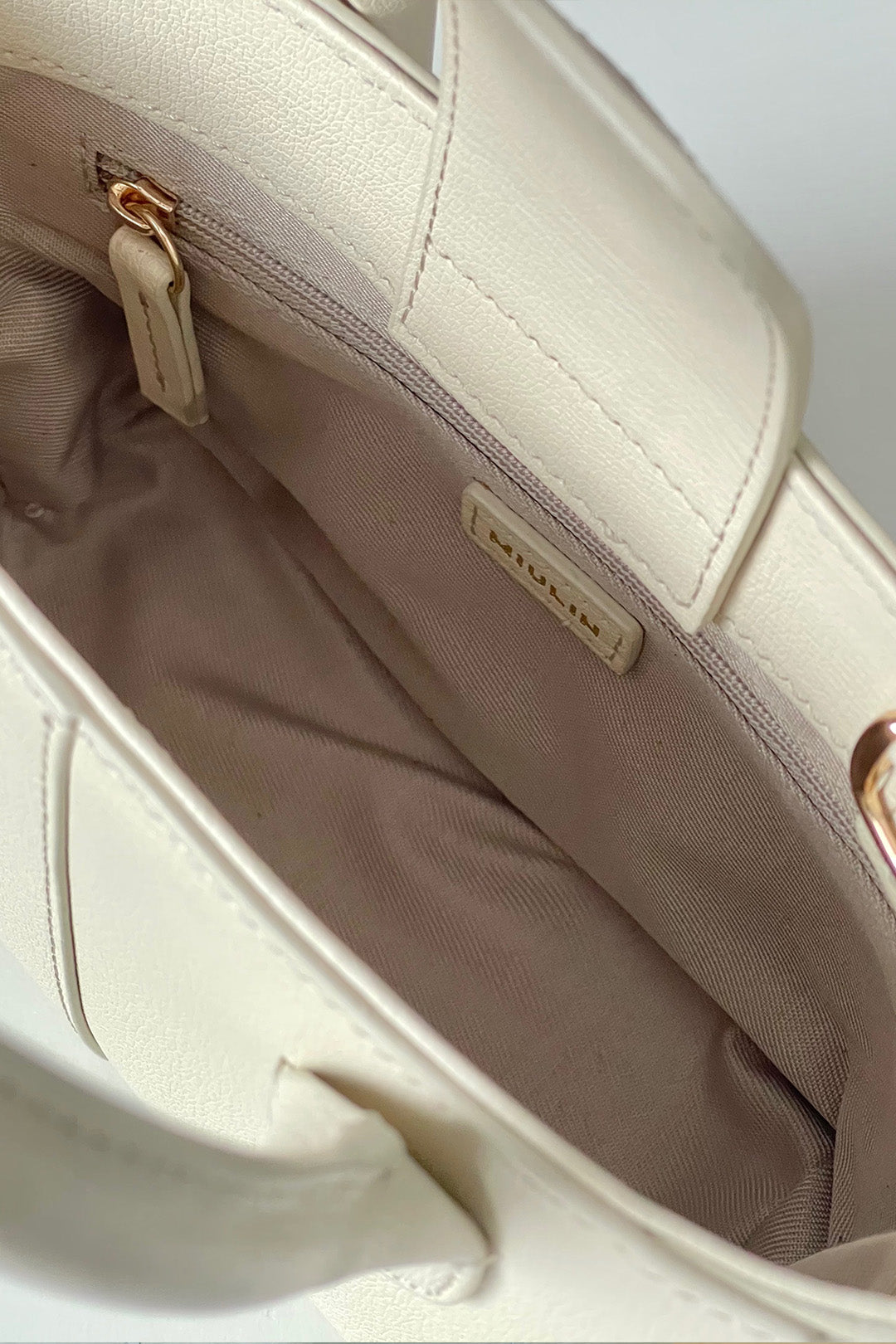 Small Ivoire leather tote bag by MIULIN with sleek design and top handles, showcasing smooth ivory-colored leather material.