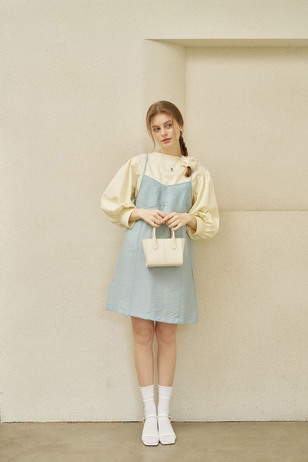 Small ivory leather bag by MIULIN featuring a sleek design and elegant handles.