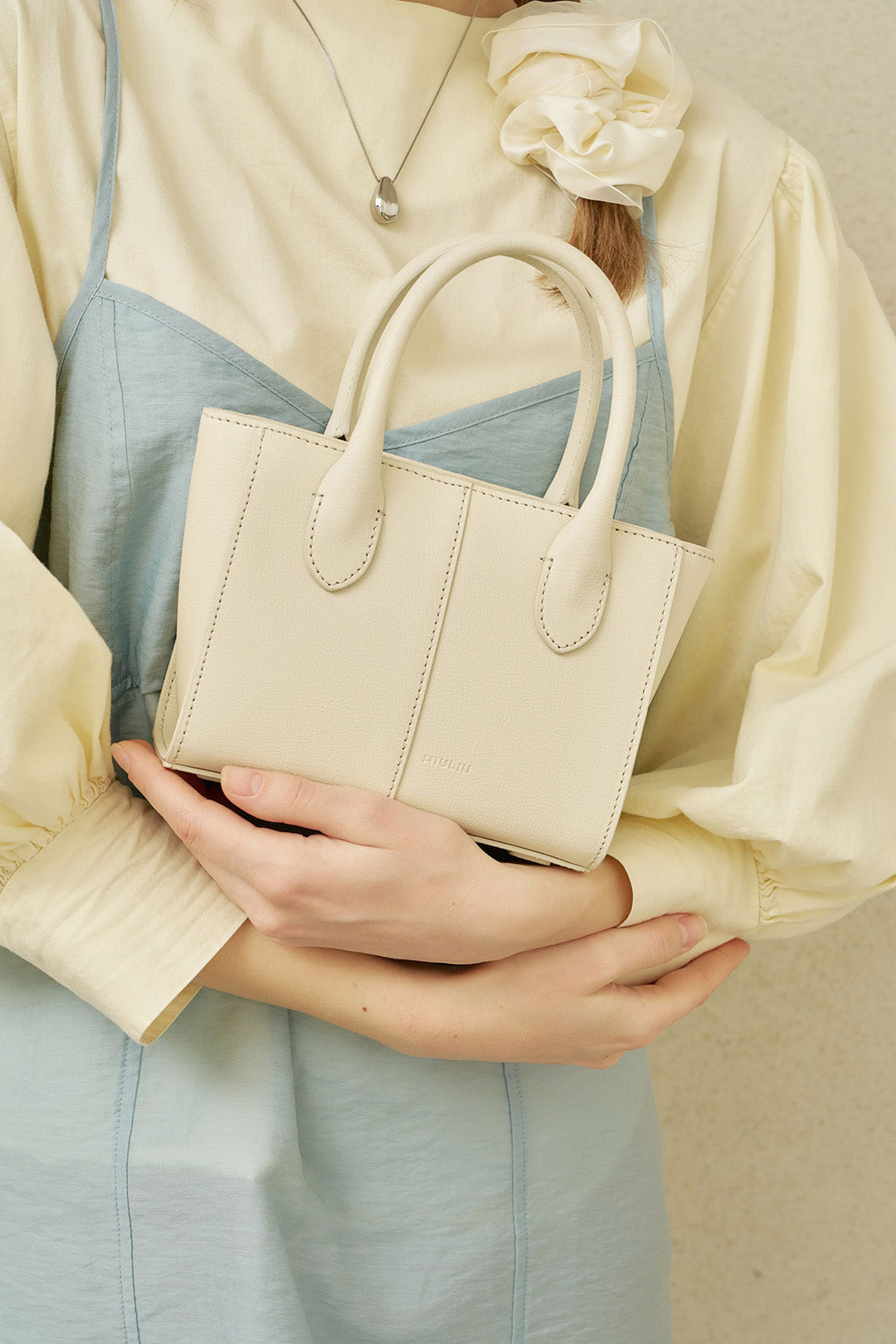 Small Ivoire leather bag by MIULIN featuring a sleek, compact design with a smooth leather finish and minimalist style.