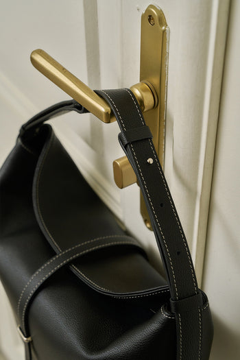 Black MIULIN Shellie Hobo Bag with rounded shape and shoulder strap, featuring a sleek, minimalist design.