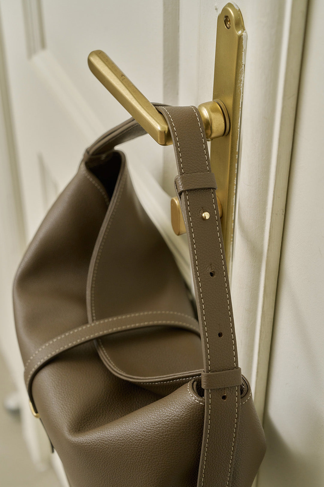 MIULIN Shellie Hobo Bag in Etoupe color with rounded shape, soft leather, and adjustable strap, displayed on a neutral background.