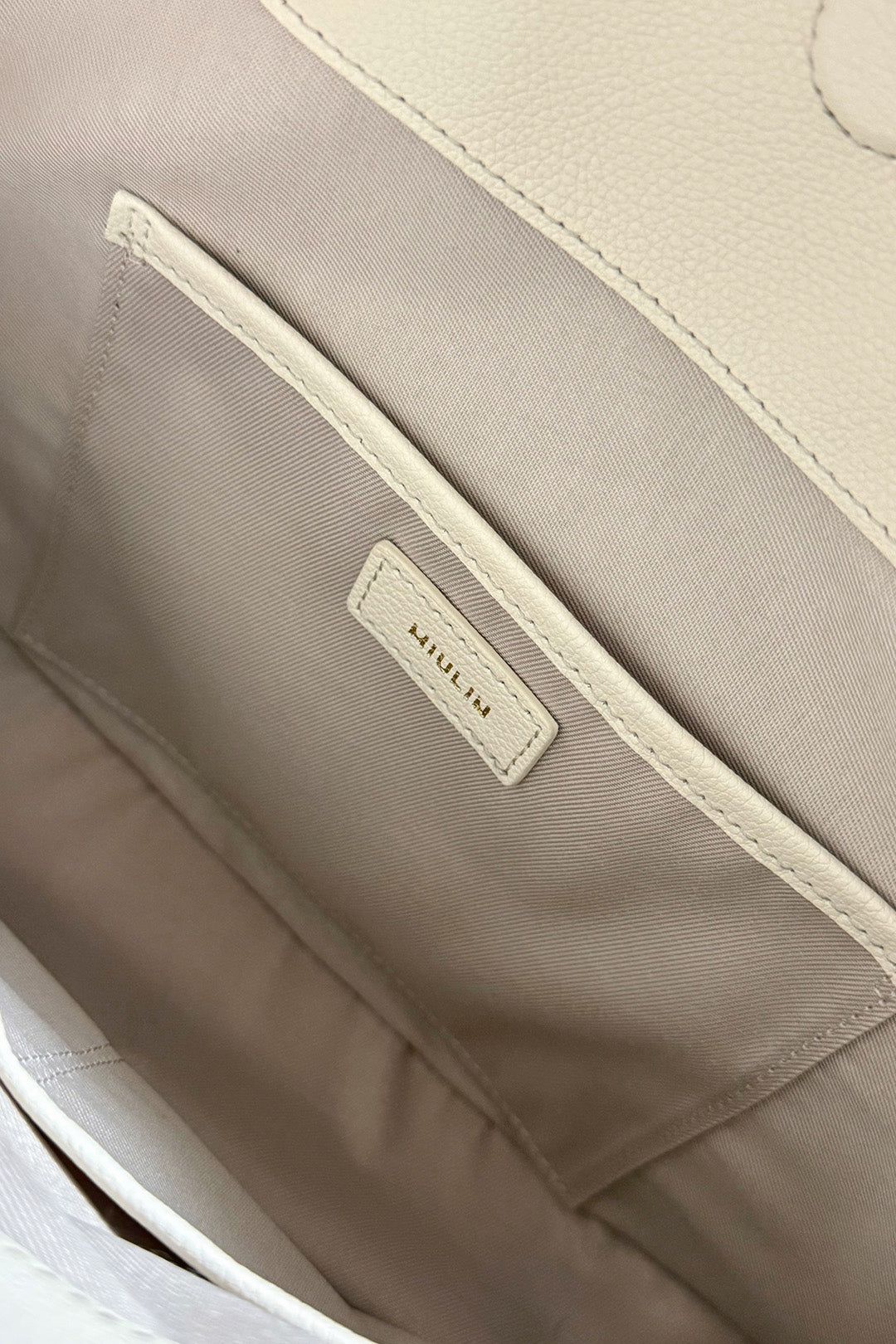 Ivory Shellie Hobo Bag by MIULIN, showcasing soft leather with a slouchy, casual design and top handles for everyday style.