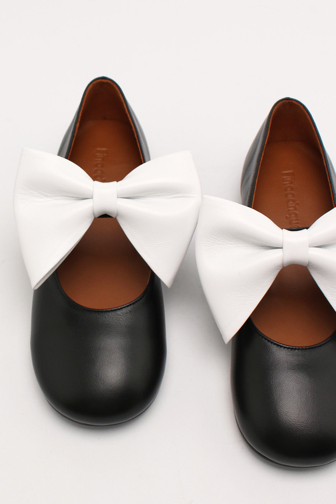 Finoacinque Soo Bow Mary Jane flat shoes in black and white with a decorative bow, displayed on a white background.