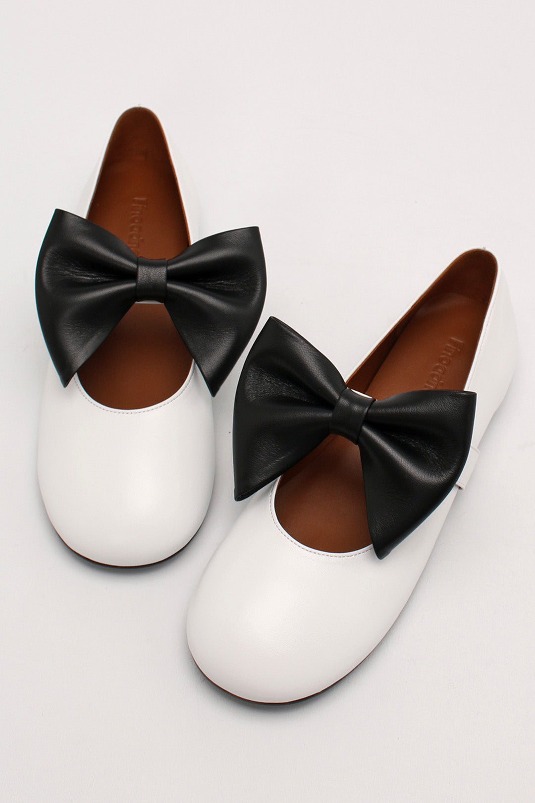 Finoacinque Soo Bow Mary Jane flat shoes in white and black with a bow detail, featuring a classic T-strap design.