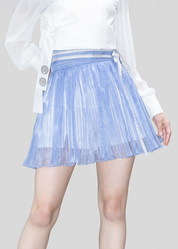 Black Ahhorn pleated mini skirt with a high-waisted, structured design, shown on a model in a casual outfit.