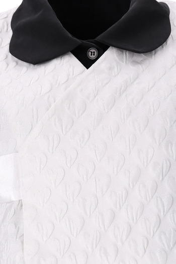 White Heart Jacquard Short Baeja Vest by Ahhorn, a stylish sleeveless top with intricate heart pattern and textured fabric.