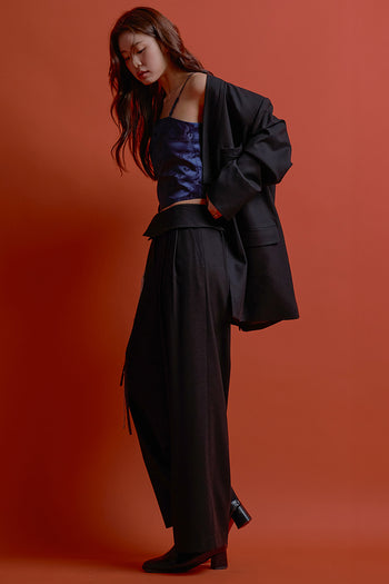 Black four-panel wrap pants by CCOMAQUE, stylish bottoms with a layered design and comfortable fit, shown on a model.