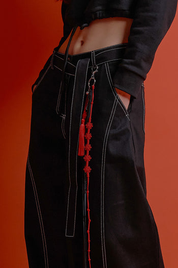 Black CCOMAQUE four-panel wrap pants with a relaxed fit, shown on a model, showcasing stylish and comfortable bottoms.