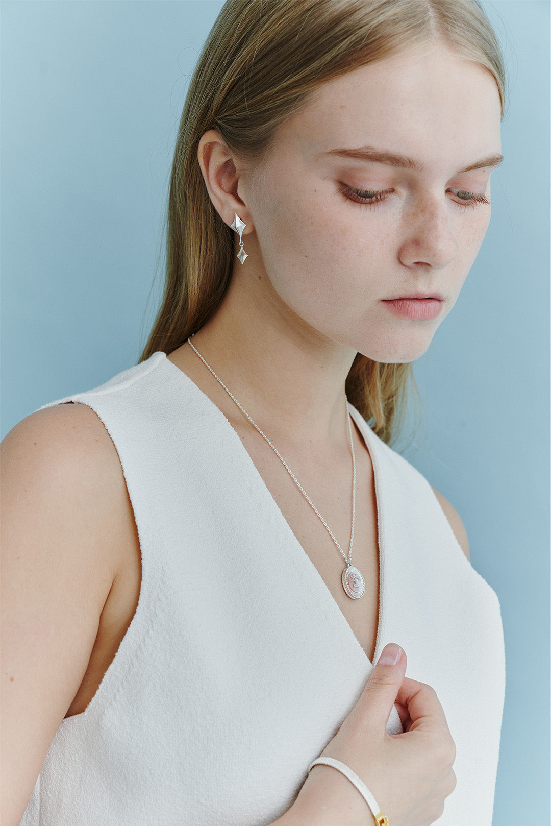 Chambriller luminous silver dangle earring with elegant design, showcasing a shiny, reflective surface and intricate detailing.