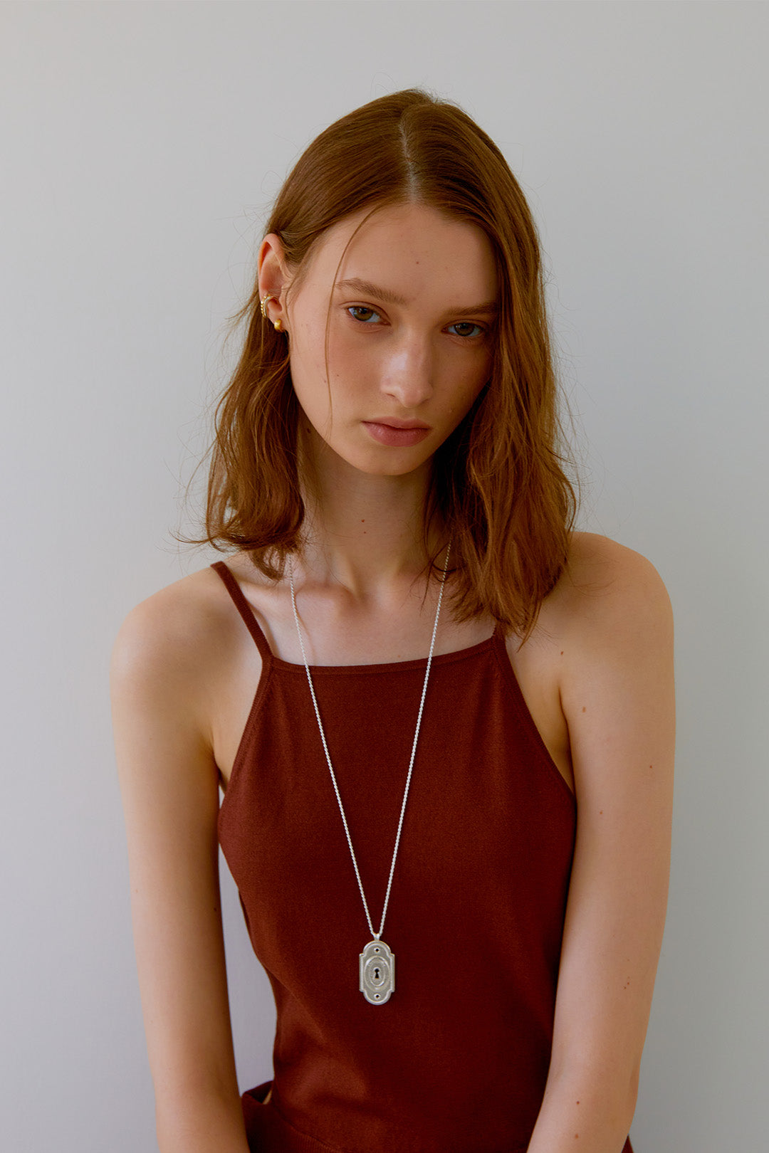 Silver lock pendant necklace by Chambriller featuring a sleek, minimalist design on a matching chain.