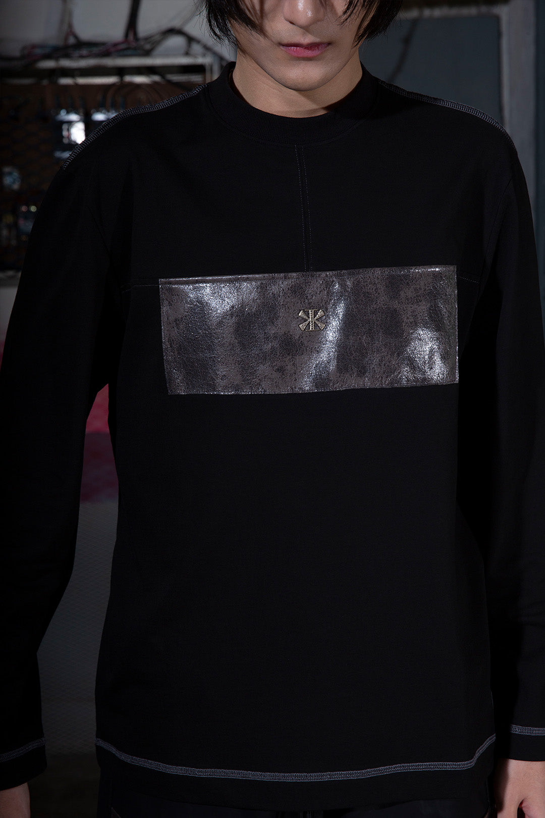 KIMMICK creviced patchwork long sleeve black top with unique textured design, fitted style, and crew neckline.