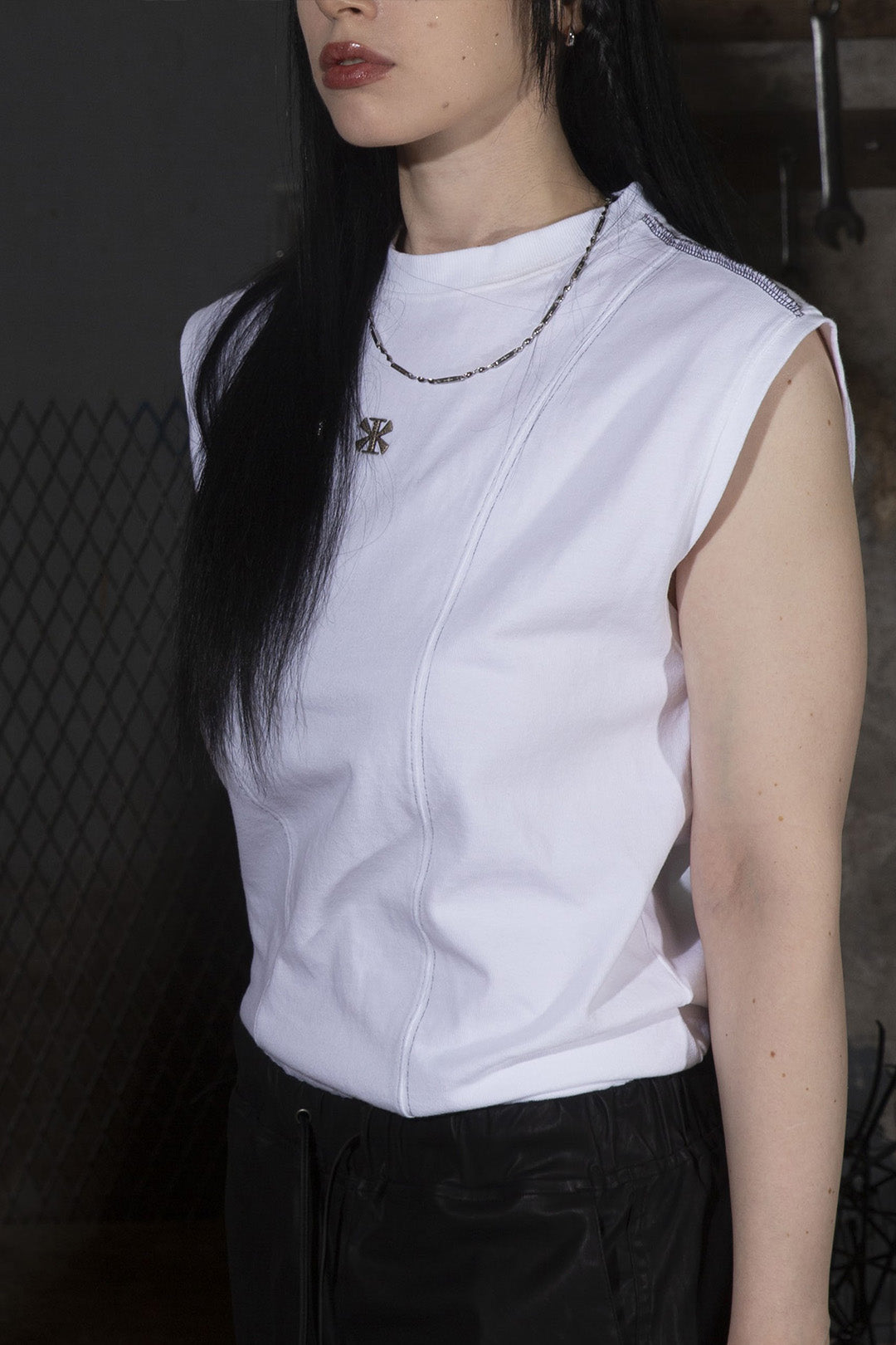 White creviced stealth-stitched sleeveless top by KIMMICK, showcasing detailed stitching and modern sleeveless design.