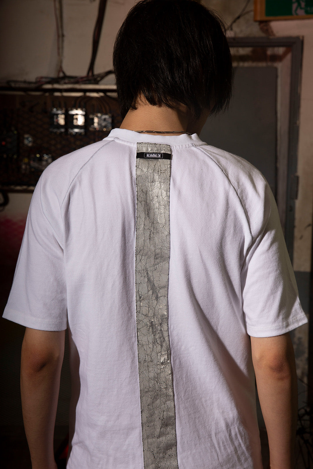 Close-up of a white creviced bite raglan half sleeve top by KIMMICK, showing fabric texture and sleeve detail.