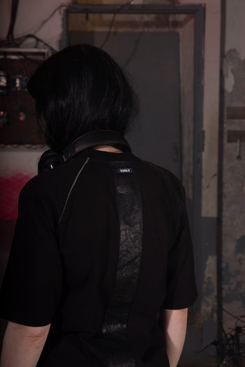 Closeup of a black creviced bite raglan half sleeve top by KIMMICK, showcasing the textured fabric and casual fit.