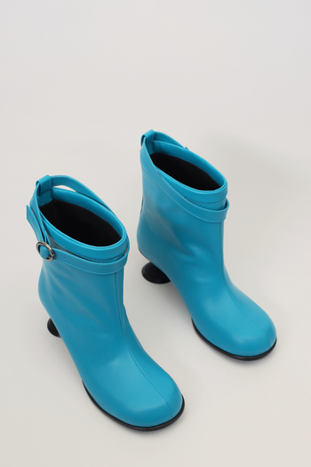 Finoacinque Uhjeo blue hourglass middle heel strap boots showing stylish ankle-high design with buckle straps and pointed toe.