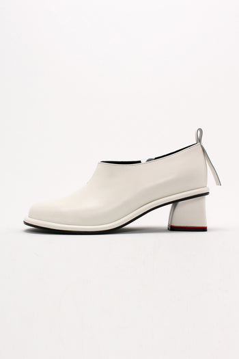 Finoacinque ivory Moon short boots displayed on a model, showcasing stylish ankle-length boots with a sleek design and pointed toes.