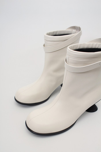 White Uhjeo Hourglass Middle Heel Strap Boots by Finoacinque featuring ankle straps and a sleek silhouette.