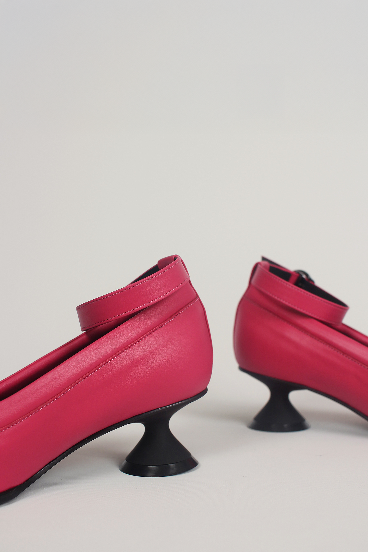 Finoacinque Uhjeo Fuchsia Pink hourglass middle heel strap pumps, stylish and vibrant footwear with a sleek design.