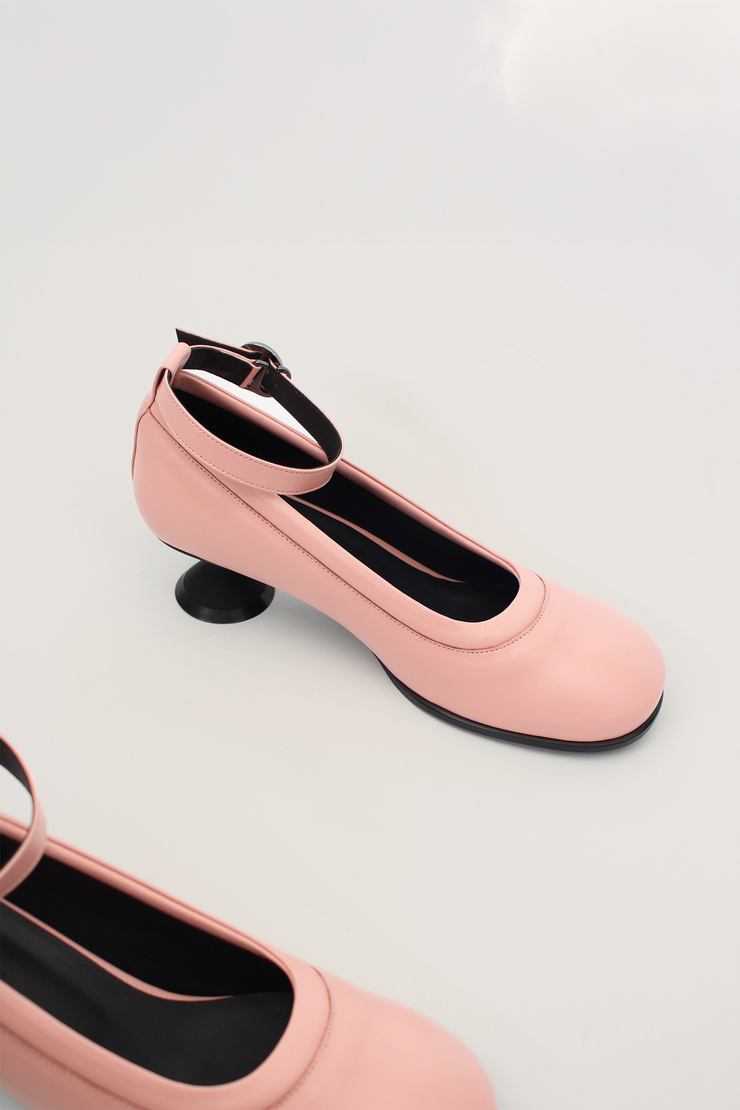 Finoacinque Uhjeo light rose hourglass middle heel strap pumps showing elegant design and ankle strap detail.