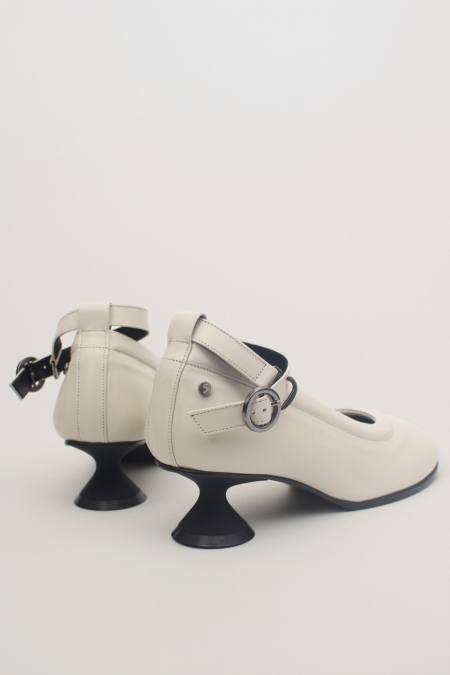 White Uhjeo hourglass middle heel strap pumps by Finoacinque featuring a sleek design and comfortable mid-height heel.