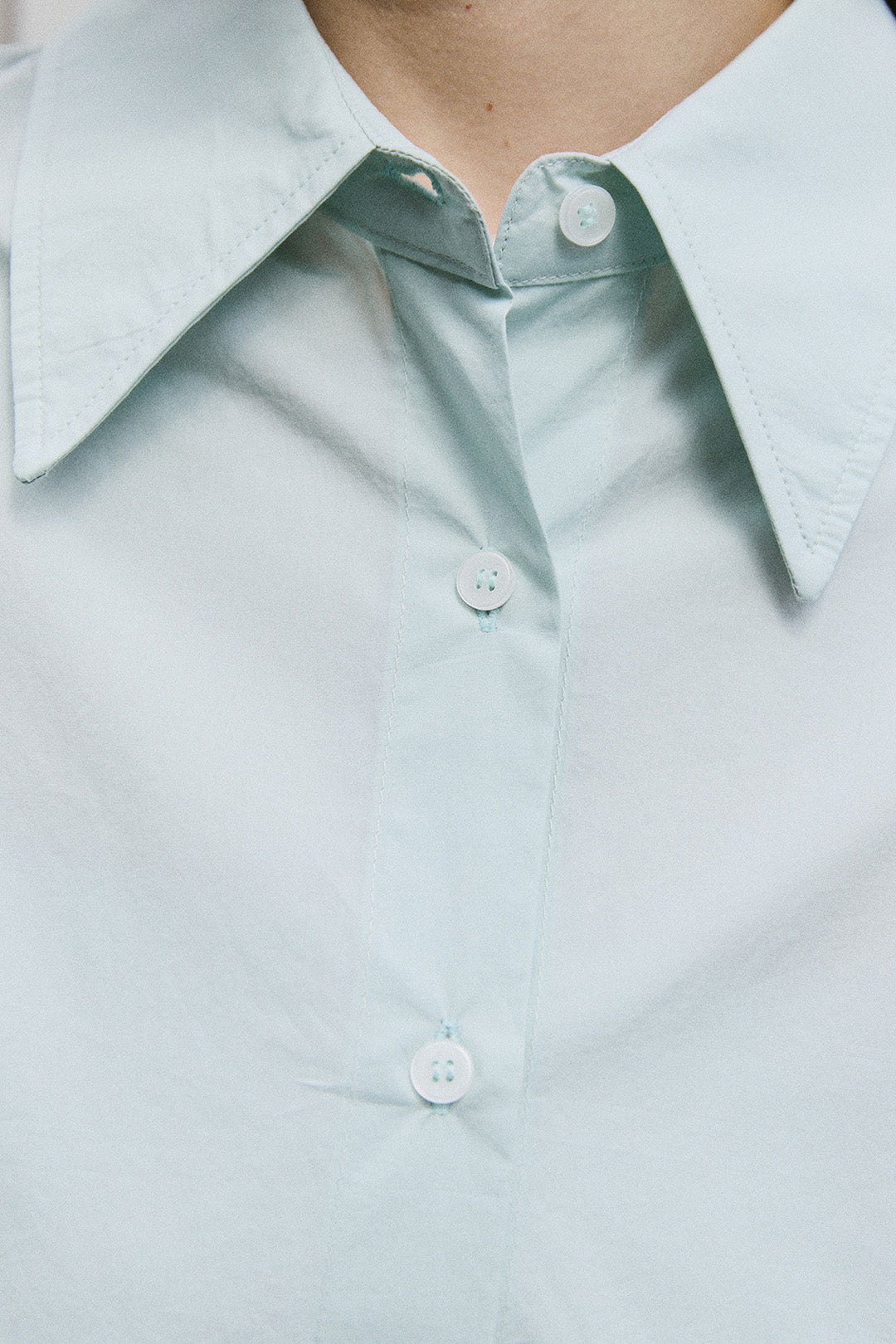 EUNJO oversized Sky Icing shirt featuring a relaxed fit and soft fabric, displayed on a hanger against a plain background.