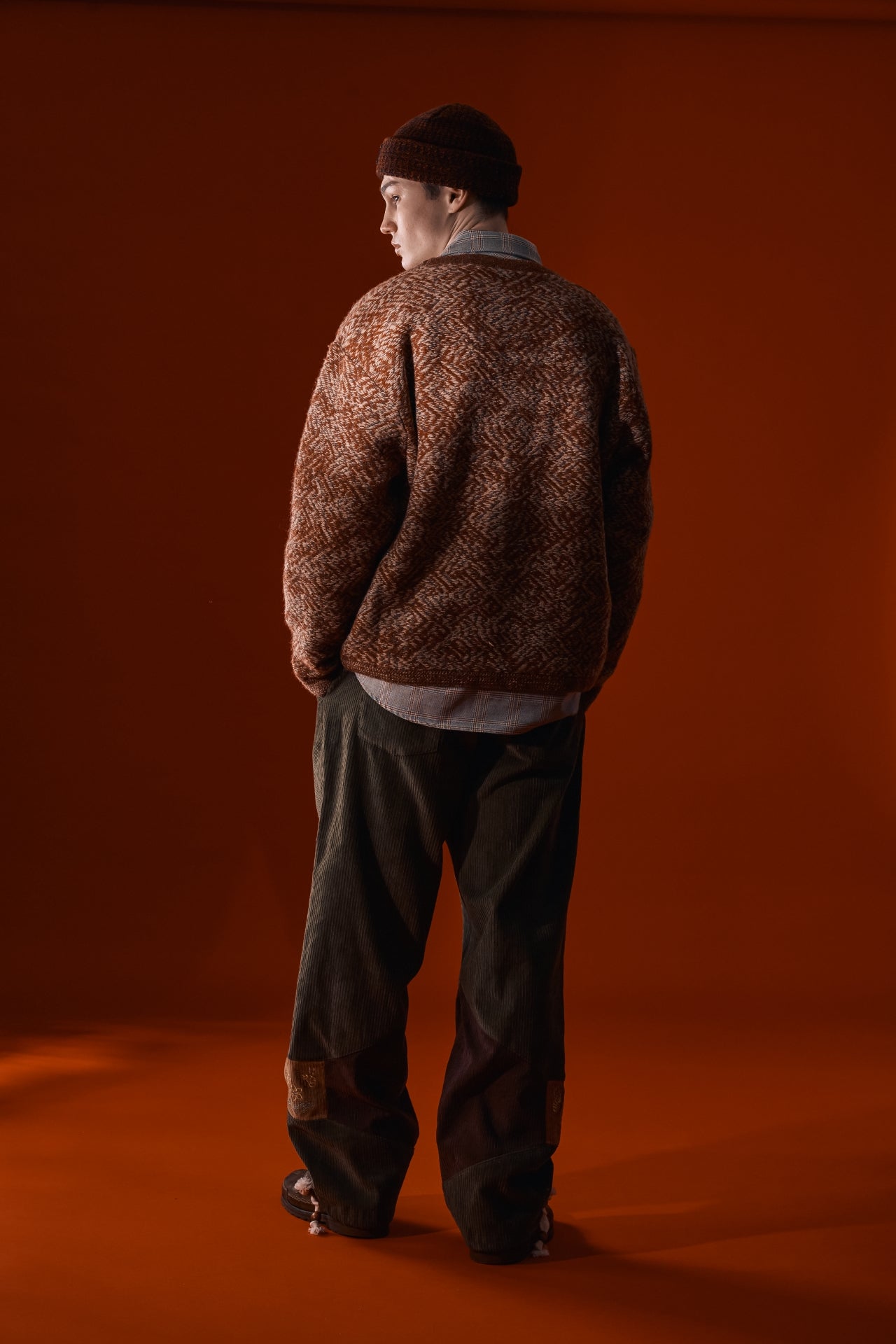 Red and brown flowing landscape short beanie by IOEDLE, shown on a model with a snug fit and soft knit texture.